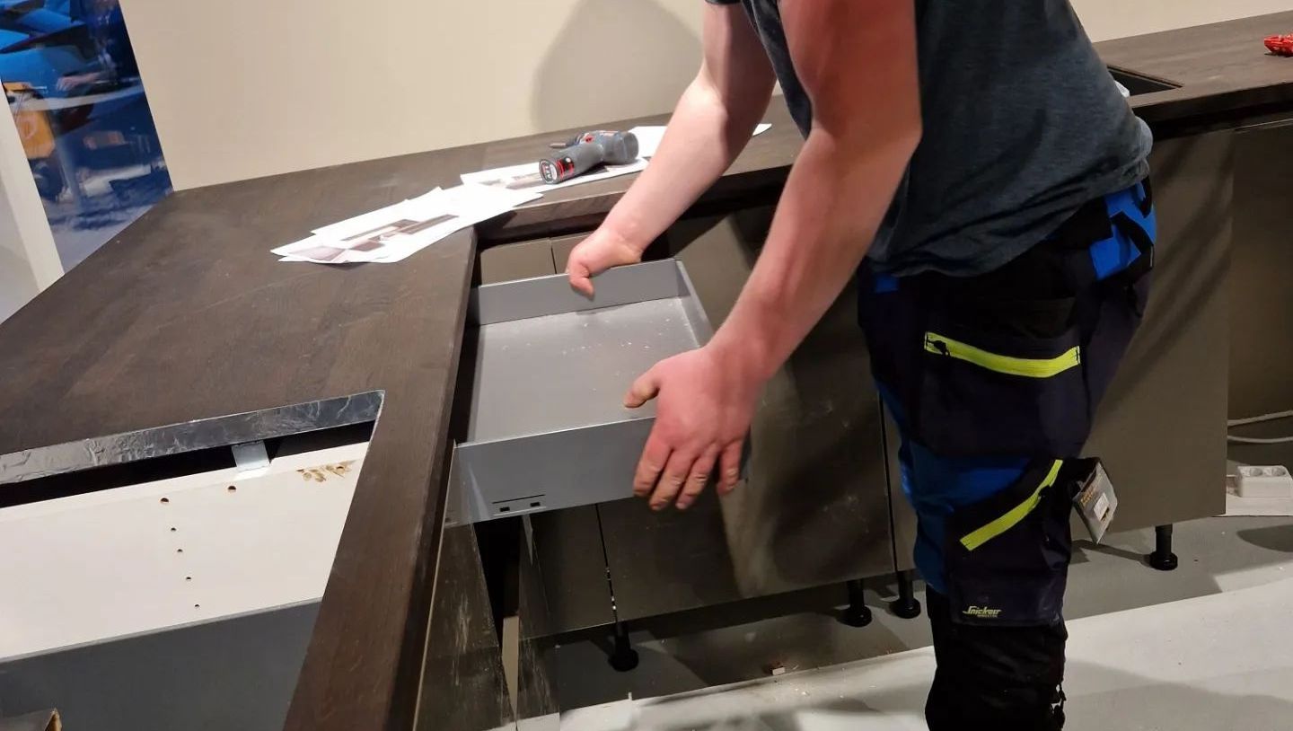 Mann som monterer kjøkken